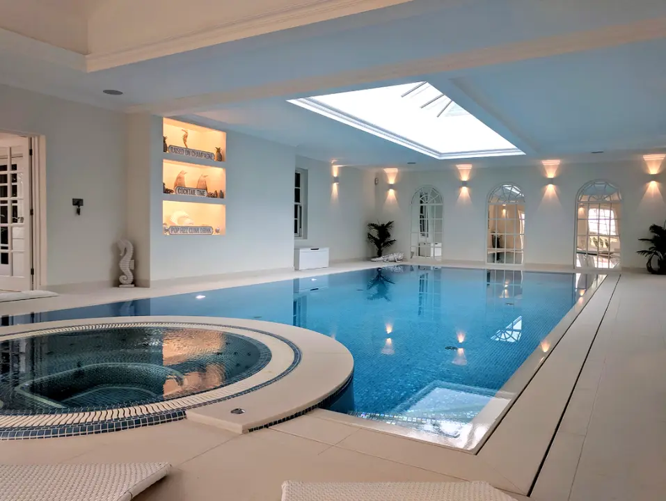 Indoor swimming pool and spa with rooflights and contemporary interior finishes.